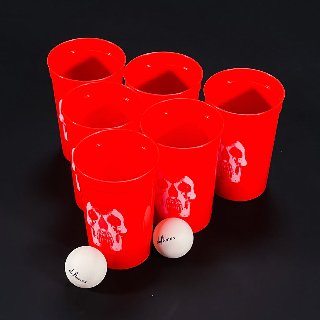 Stack of red plastic cups with a skull logo, packaged as Deftones merchandise.